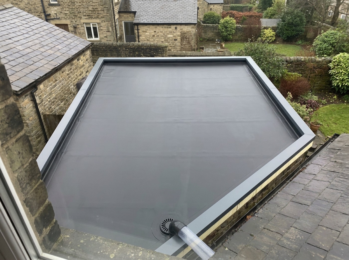 The same extension roof in seamless dark EPDM, dry and flat with crisp new edge trims